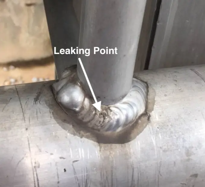 Edited Field image marking the reported leak location at a welded branch connection.
