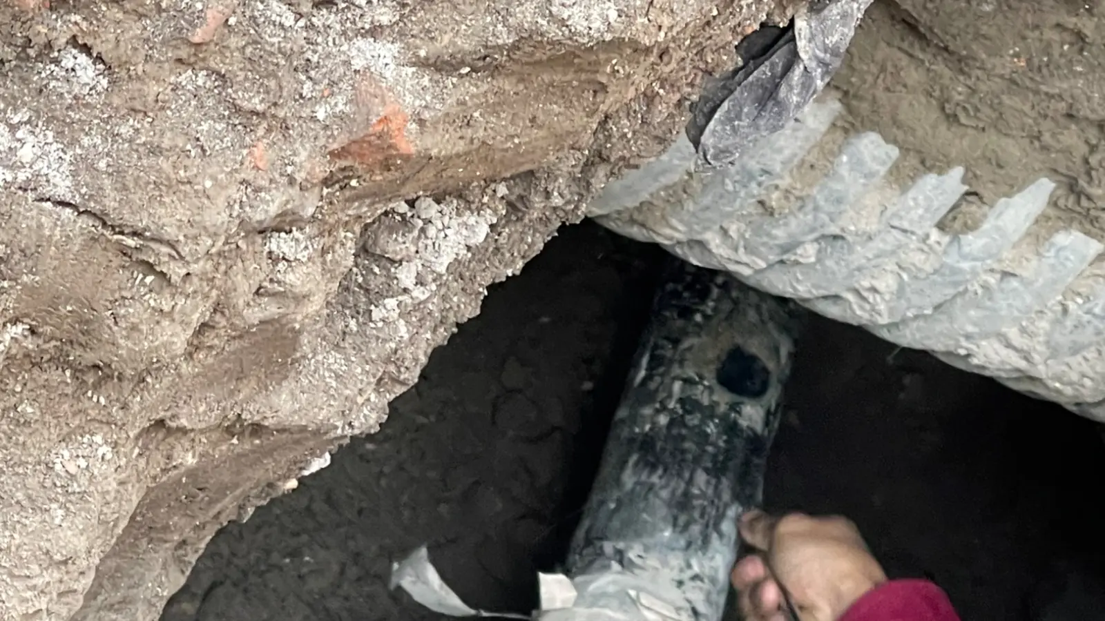 Buried insulated natural gas pipe in an excavated, constrained area.