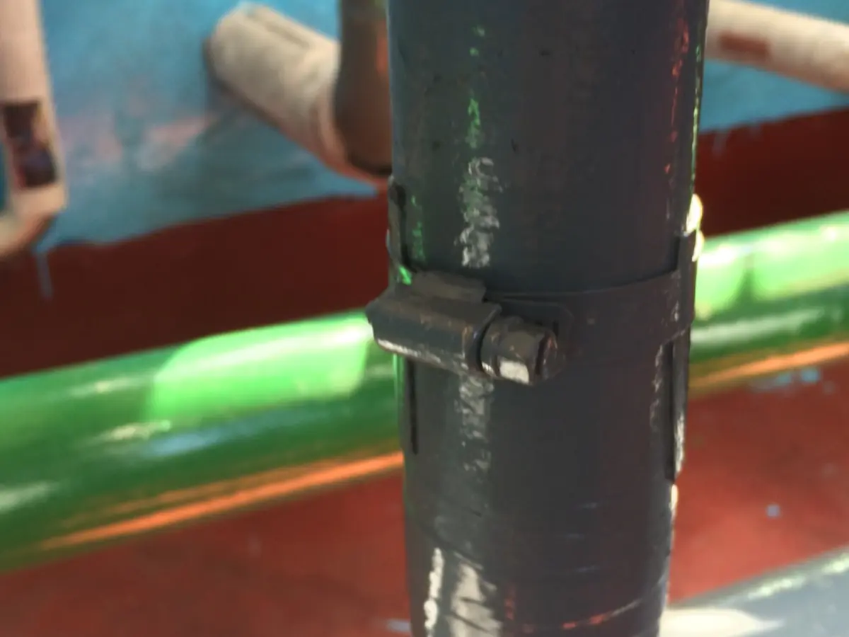 Wider view of the prior metal clamp arrangement on the DN100 line.